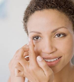 Woman putting in contact lenses